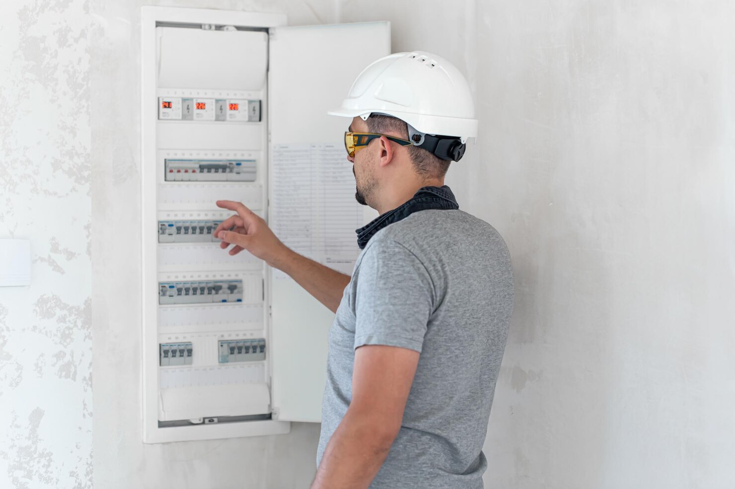electrical-technician-looking-focused-while-working-switchboard-with-fuses_169016-23482